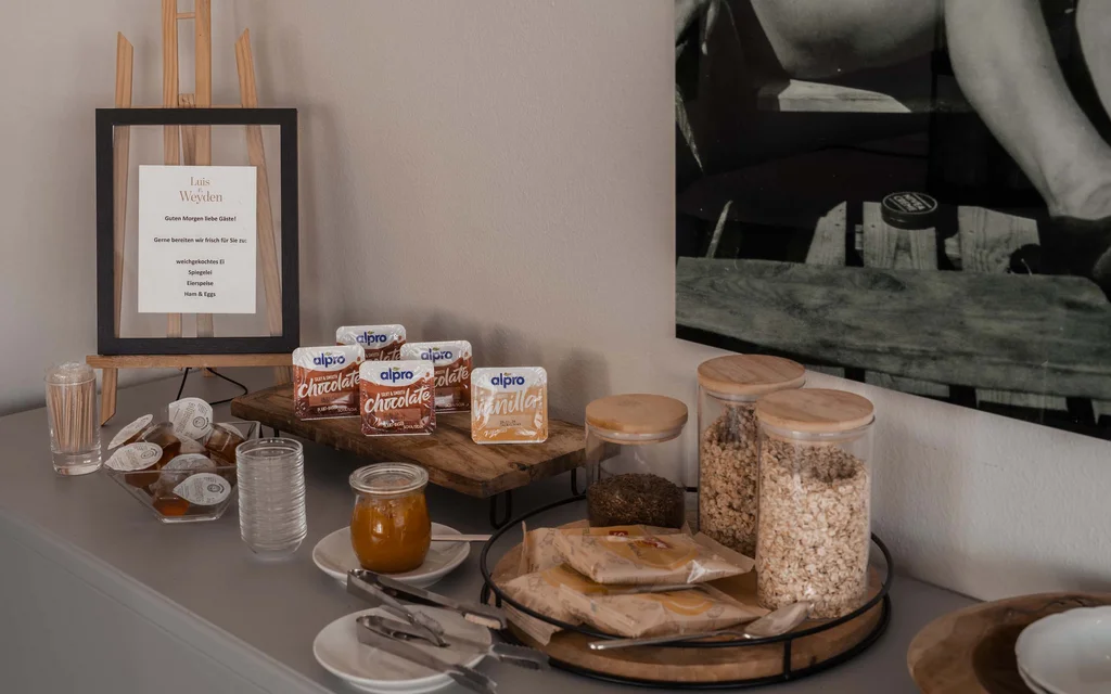 Frühstücksbuffet mit Cerealien, Aufstrichen und Behältern auf der Theke