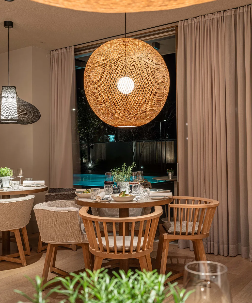 Gemütlicher Essbereich mit Holzstühlen und warm beleuchteter Deckenlampe