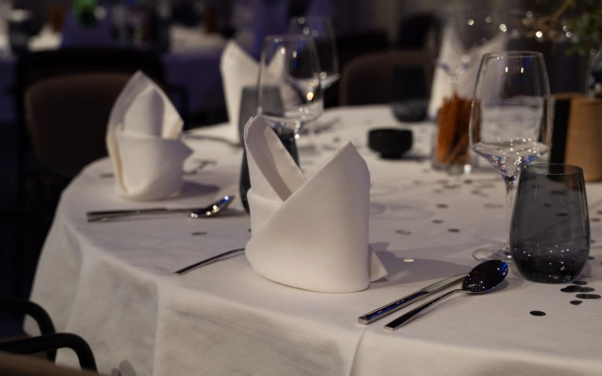 Eleganter gedeckter Tisch mit weißen Servietten und Gläsern in einem Restaurant