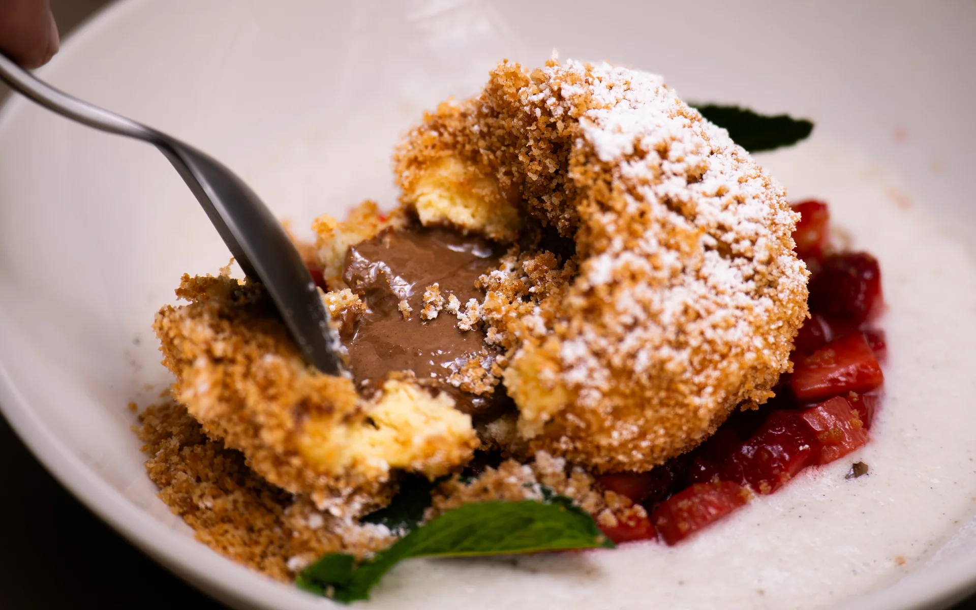 Ankkuri: Our restaurant near Parndorf Dessert with creamy chocolate filling, powdered sugar, and fruit pieces