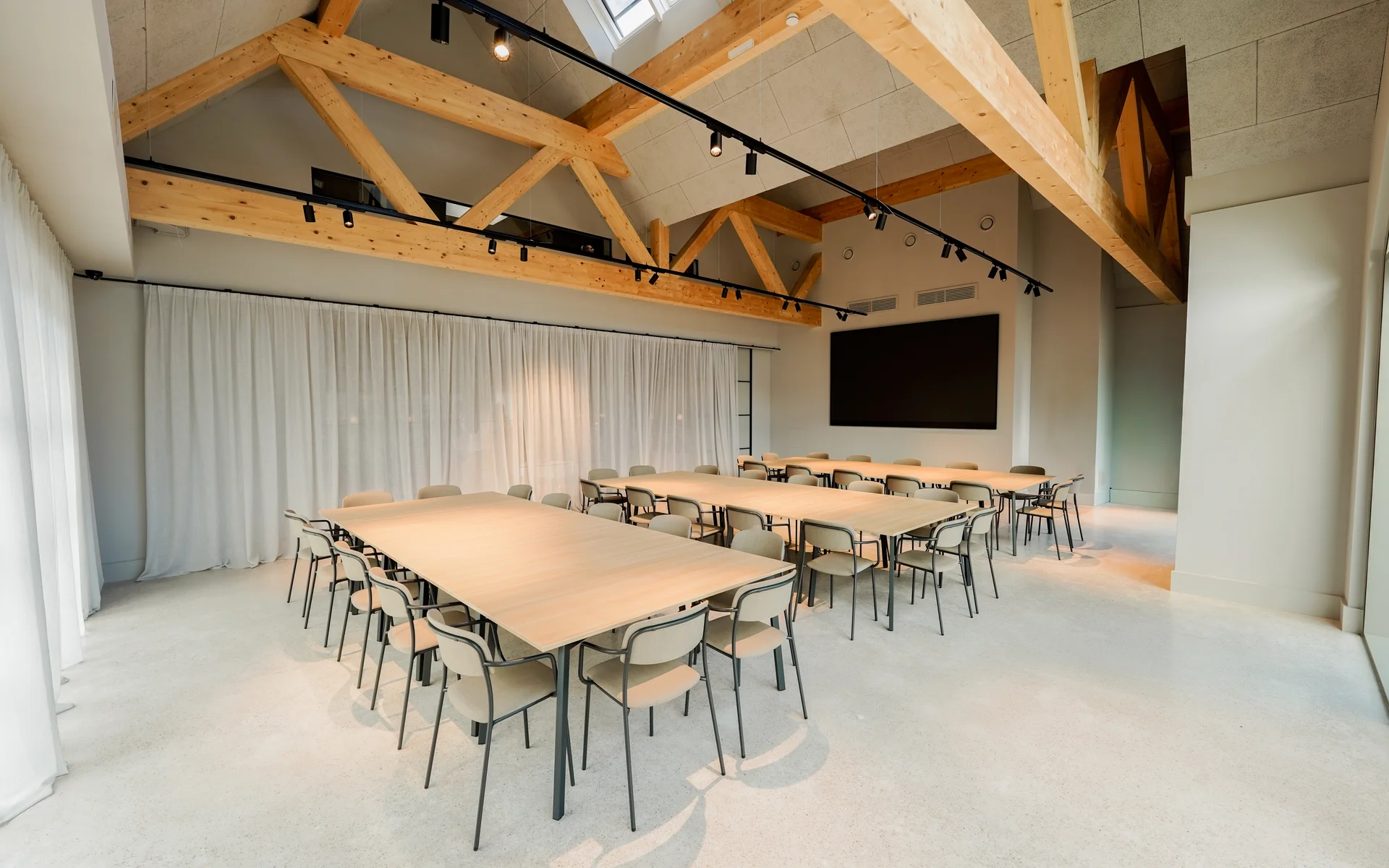 NILS am See: unser Event- und Seminarhotel im Burgenland Moderner Konferenzraum mit Holzbalken und angeordneten Tischen und Stühlen