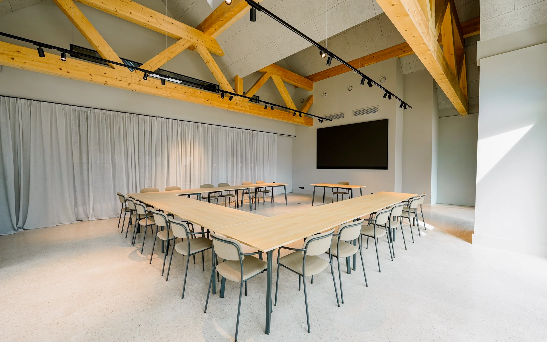 NILS am See: unser Event- und Seminarhotel im Burgenland Leerer moderner Konferenzraum mit Holzstühlen und großen Holzbalken an der Decke